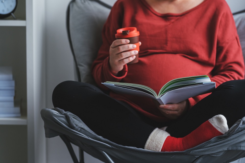 Senior Pregnant woman reading book about pregnancy